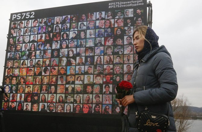 A woman lays flowers to a memorial in Kyiv, Ukraine, Friday, Jan. 8, 2021, for the victims of a Ukrainian 737-800 plane crash on the outskirts of Tehran. (AP)