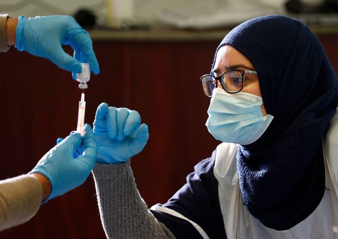 An Oxford/AstraZeneca COVID-19 vaccine is prepared at the Al-Abbas Islamic Centre, which has been converted into a temporary vaccination centre in Birmingham, central England on January 21, 2021. (AFP)