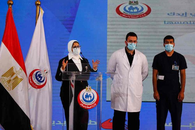(L to R) Egyptian Health Minister Hala Zayed gives a press conference, accompanied by doctor Abdelmouim Selem and medical staff member Ahmed Hemdan, in a tent set up outside the Abou Khalifa hospital, in Ismailia, about 120 kilometers (75 miles) east the capital Cairo, on Sunday Jan. 24, 2021, after the two men received a doze of a coronavirus vaccine. (AFP)