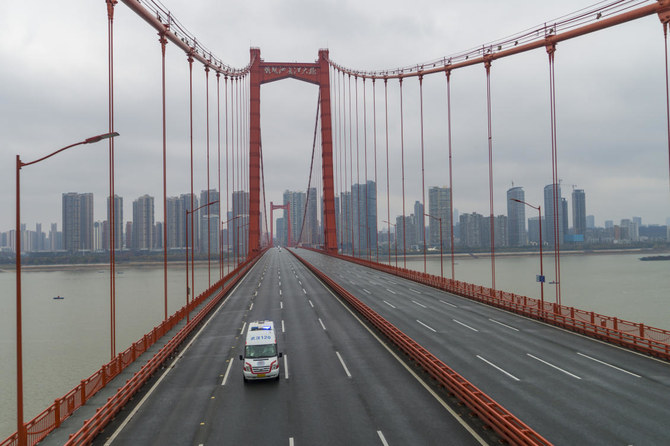 In this Jan. 25, 2020, file photo, an ambulance drives across a nearly empty bridge in Wuhan, China, after the city was placed under a 76-day lockdown amid a rising COVID-19 outbreak. China managed to place the contagion under control early while other countries continue to suffer from the pandemic one year after. (Chinatopix via AP, File)