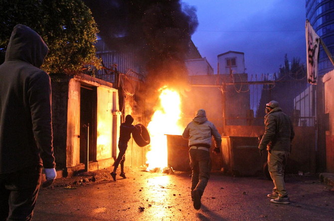 Demonstrators set a fire near the government Serail building, during a protest against the lockdown and worsening economic conditions, in Tripoli, amid the spread of COVID-19. (Reuters)