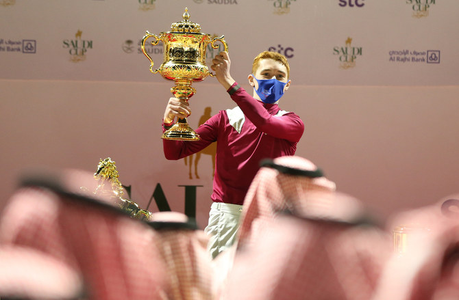Jockey David Egan celebrates with the trophy after winning the Saudi Cup riding Mishriff. (Reuters)