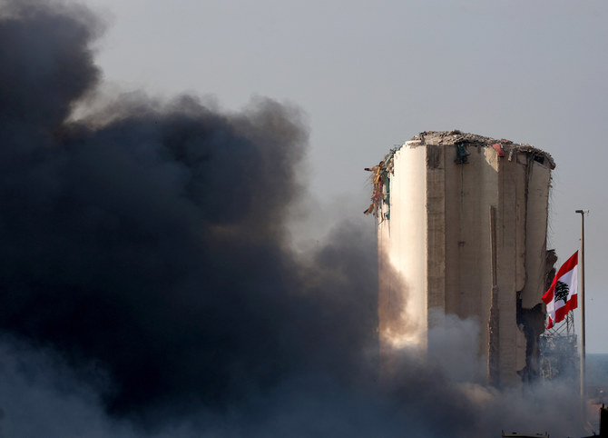 The Lebanese flag flies next to the Beirut port silo, damaged in the August 4 explosion, as smoke billows from a huge fire there on September 10, 2020. (AFP/File Photo)