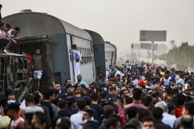 People gather by an overturned train carriage at the scene of a railway accident in the city of Toukh in Egypt's central Nile Delta province of Qalyubiya on April 18, 2021. (AFP/File Photo)