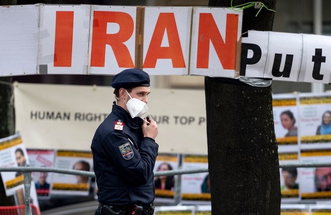 A police officer patrols in front of banners put up by members of the National Council of Resistance of Iran, an Iranian opposition group, in front of the Grand Hotel Wien. (AFP)