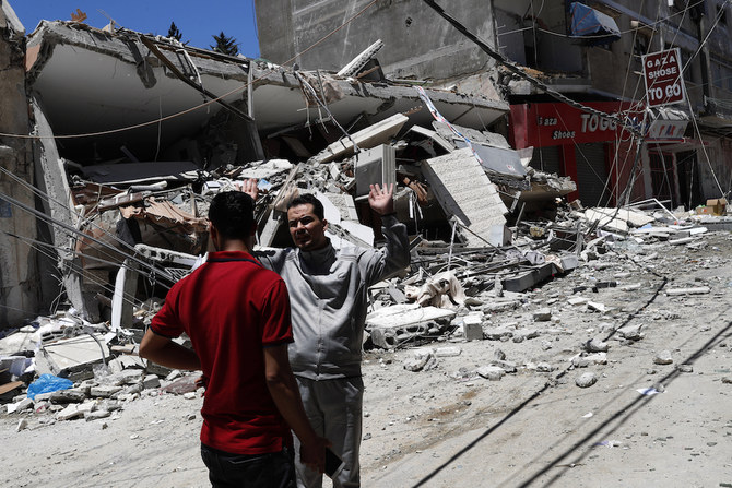 Palestinians react in front of the remains of destroyed building after being hit by Israeli airstrikes in Gaza City, Thursday, May 13, 2021. (AP)