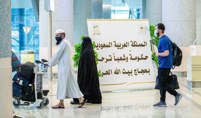 This file photo shows travellers walking with luggage past a welcome sign at the Red Sea coastal city of Jeddah's King Abdulaziz International Airport. (AFP)
