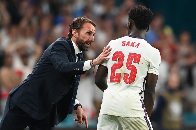 England's coach Gareth Southgate (L) speaks with England's midfielder Bukayo Saka during the UEFA EURO 2020 final football match. (AFP)