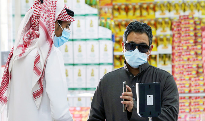A man displays his details on his mobile phone using the Tawakkalna app as he enters the Al-Othaim market in Riyadh, Saudi Arabia. (REUTERS file photo)