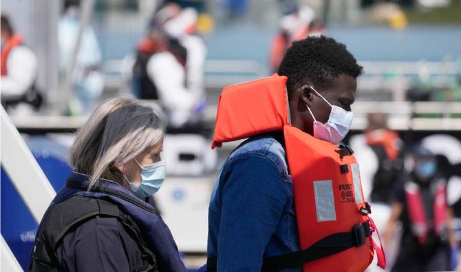 A man thought to be a migrant who made the crossing from France is escorted along a walkway after disembarking from a British border force vessel, in Dover, south east England, Thursday, July 22, 2021.  (AP)