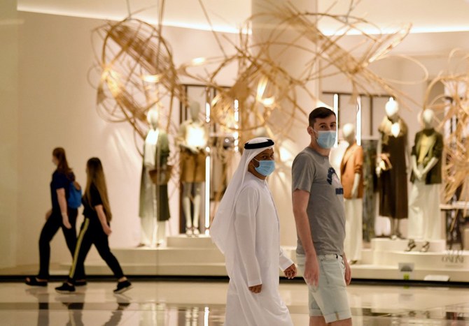 People wearing masks for protection against the coronavirus, walk in the Mall of Dubai. (AFP)