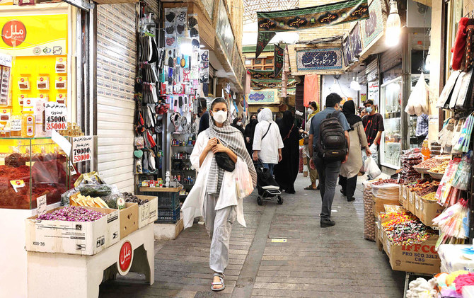 Mask-clad people shop at the Tajrish Bazaar market in Tehran on Sunday. Iran tightened curbs to contain the spread of the coronavirus. (AFP)