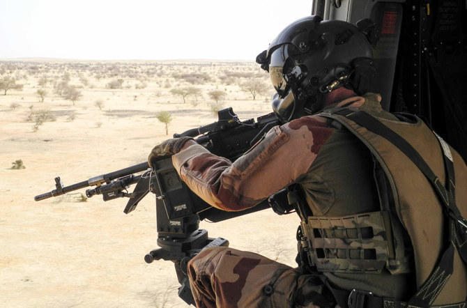 A French soldier from the Barkhane mission in Africa's Sahel region, points a machine gun from a NH90 helicopter between Gao and Menaka, Mali, on March 21, 2019. (AFP)