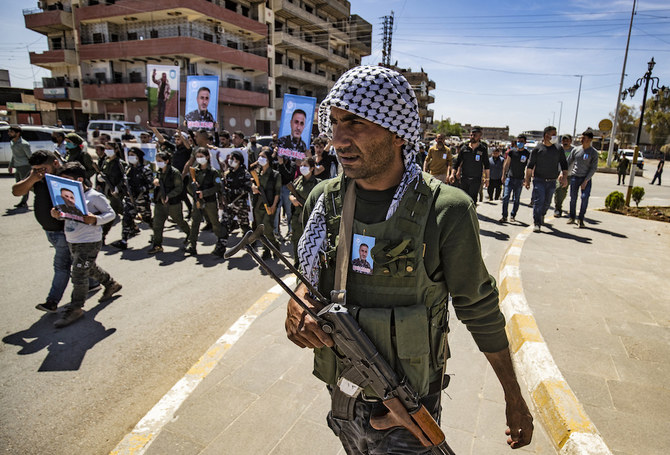 Members of the Syrian Kurdish internal security services known as “Asayish” march in a procession ahead of the body of their fallen comrade Khalid Hajji. (AFP/File Photo)