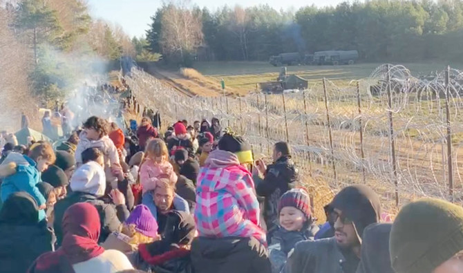 Migrants gather near a barbed wire fence on the Poland - Belarus border in Grodno District, Belarus, in this still image taken from a social media video on November 9, 2021. (Reuters)