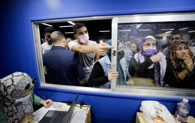 People wait to receive a dose of the coronavirus disease (COVID-19) vaccine at an immediate vaccination center operating at the Sadat underground metro station, in Cairo. (Reuters)
