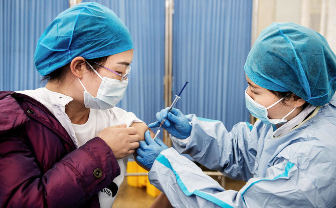 A medical staff member (L) receives a booster shot of the Sinopharm Covid-19 coronavirus vaccine at a hospital in Wuhan in China's central Hubei province on November 25, 2021. (AFP)