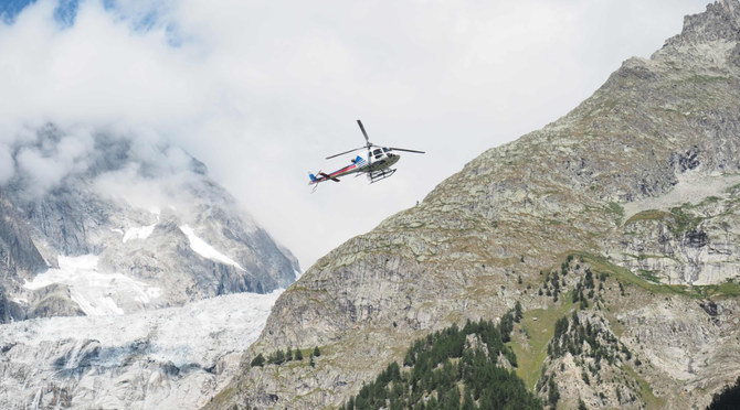 A picture taken on August 10, 2018 shows a helicopter flying over the Mont Blanc massif, on the Italian side of the Alps. (AFP) 