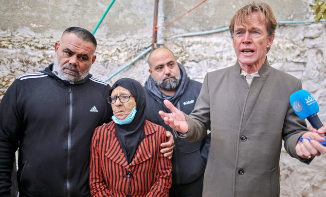 Fatima Salem (C) looks on as Sven Kuhn von Burgsdorff, head of the European Union's mission to the West Bank and Gaza Strip (R) speaks to the media during his visit to her home in Sheikh Jarrah on December 20, 2021. (AFP)