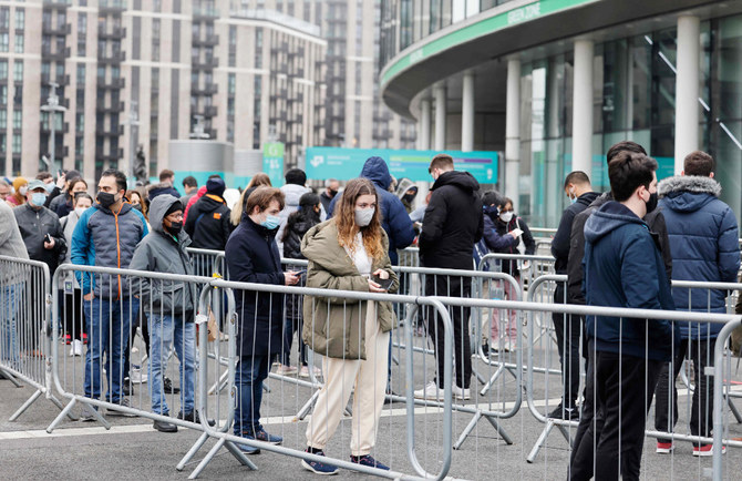 Members of the public queue outside the newly-set up Wembley Stadium vaccination centre to receive their the Covid-19 vaccine or booster at a mass vaccination event in London on December 19, 2021. (AFP)