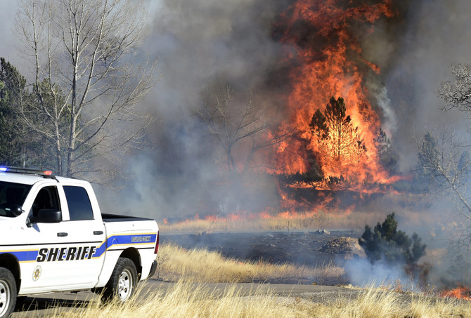 Fire continues to burn near a home at Middle Fork Road and Foothills Highway, north of Boulder, Colorado, on Dec. 30, 2021.  (Cliff Grassmick/Daily Camera via AP)