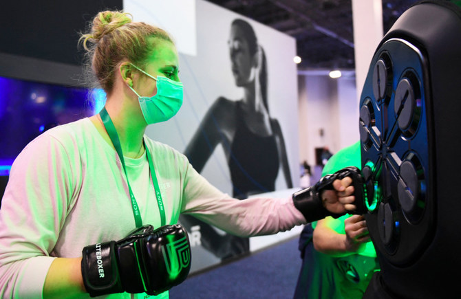 An attendee uses a Liteboxer interactive boxing home workout during the Consumer Electronics Show (CES) on January 7, 2022 in Las Vegas, Nevada. (AFP)