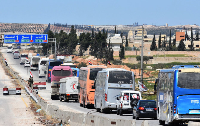 A convoy transporting fighters and their families from the former bastion's main town of Douma arrives at the entrance to the northern Syrian city of Aleppo on April 3, 2018. (AFP)