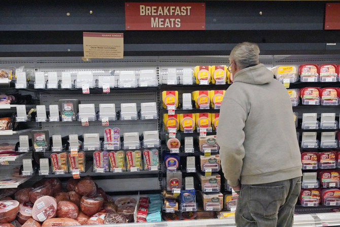 A shopper at a grocery in Pittsburgh looks at the partially empty display of breakfast meats on Tuesday, Jan. 11, 2022. (AP)