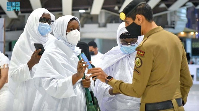 Saudi police check pilgrims for vaccination details on their smartphone, after Saudi authorities announced the easing of coronavirus restrictions, at the Grand Mosque in Makkah. (Reuters/File Photo)