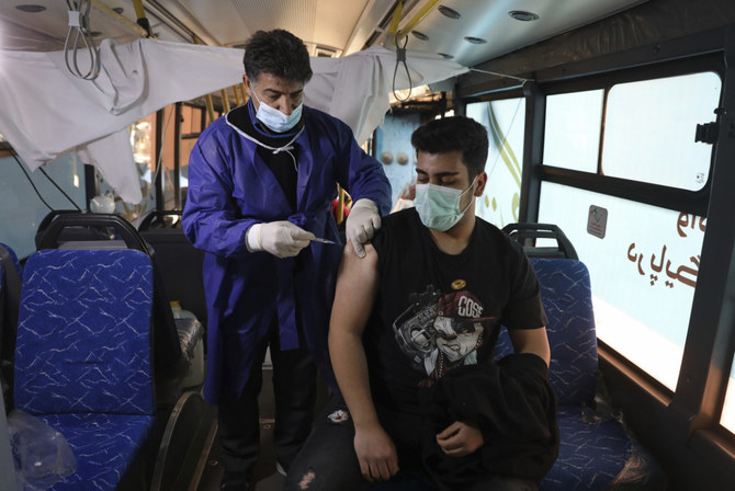 A man receives a COVID-19 vaccine at a mobile vaccine clinic bus at the Grand Bazaar of Tehran, Iran, on Jan. 22, 2022. (AP Photo/Vahid Salemi)