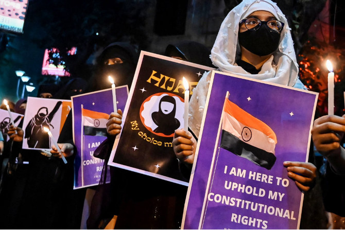 Burqa clad Muslim women hold placards as they take part in a demonstration in Kolkata on February 11, 2022, to protest after students were told not to wear hijabs in the premises of the institute. (AFP)
