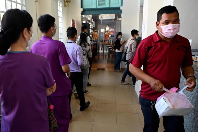 People line up inside a post office to buy rapid testing kits for the COVID-19 coronavirus in Cambodia on Monday as the country sees a surge of cases from Omicron variant. (AFP)