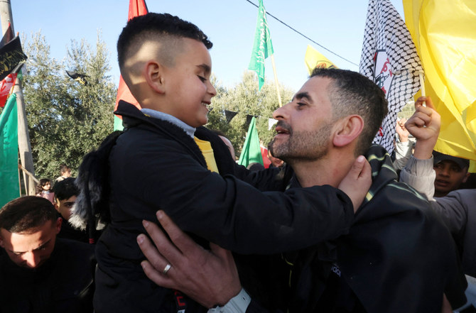 Hisham Abu Hawash (R), a Palestinian prisoner who was on a hunger strike in an Israeli prison, embraces his son upon his release in Hebron on February 24,2022. (AFP)