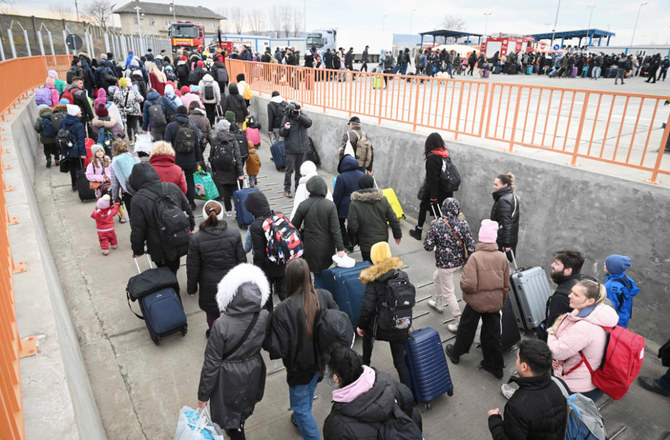 People coming from Ukraine descend from a ferry boat to enter Romania after crossing the Danube river at the Isaccea-Orlivka border crossing between Romania and Ukraine on February 26, 2022. (AFP)