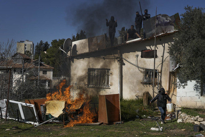 Palestinian men stand on the roof of a house as Israeli police prepare to evict a family, in the flashpoint east Jerusalem neighborhood of Sheikh Jarrah in Jan. (AP)