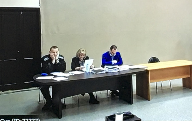 Russian opposition leader Alexei Navalny, left, is seen via a video link, sitting next to his layers during a court session in Pokrov, Vladimir region east of Moscow, Russia, Tuesday, March 15, 2022. (AP)