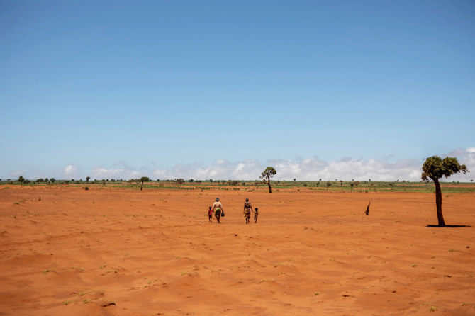 Tarira and her son Avoraza, 4, walk through a field covered with red sand in Anjeky Beanatara, Androy region, Madagascar, February 11, 2022. (REUTERS)
