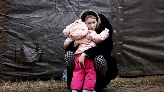 A Ukrainian woman fleeing Russian invasion hugs a child at a temporary camp in Przemysl, Poland. (Reuters)