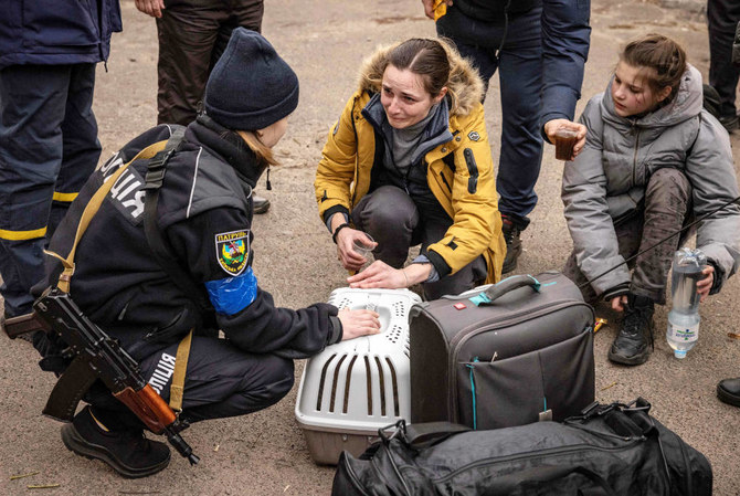 A woman reacts as she is assisted by police after fleeing in the suburbs of Kyiv, on March 26, 2022, during Russia's military invasion launched on Ukraine. (AFP)