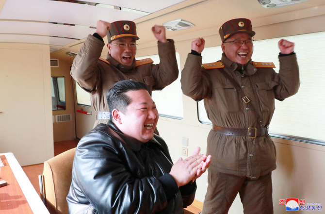 North Korean leader Kim Jong Un reacts next to military officials during  the launch of the "Hwasong-17" intercontinental ballistic missile on March 25, 2022. (REUTERS)