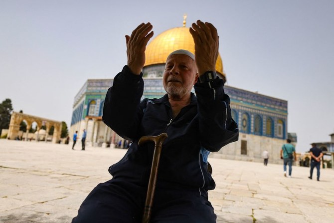 A Palestinian man prays in front of the Dome of Rock mosque at the Al-Aqsa mosque compound in Jerusalem's Old City. (AFP)