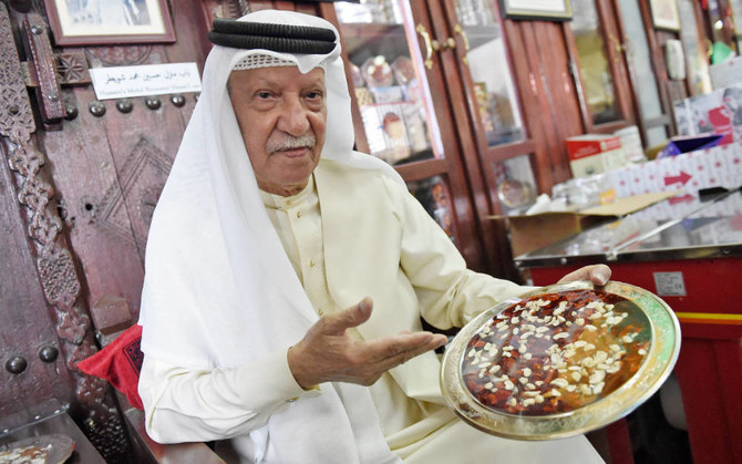 Head of stores and sales at Hussain Showaiter Sweets Mohammed Ghareb shows the various kinds of Bahraini sweets on Muharraq Island. (AFP)