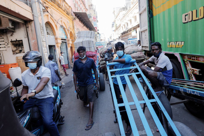 Men wait with their carts at a market, amid the country's economic crisis in Colombo, Sri Lanka. (REUTERS)