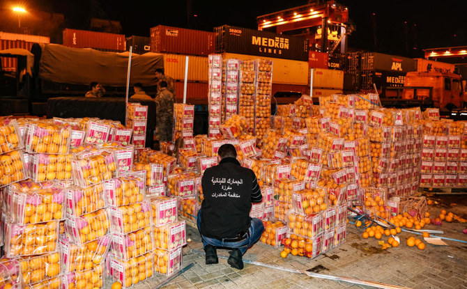 A customs agent checks boxes of oranges, in which fake fruits filled with Captagon in the Lebanese capital. (AFP)