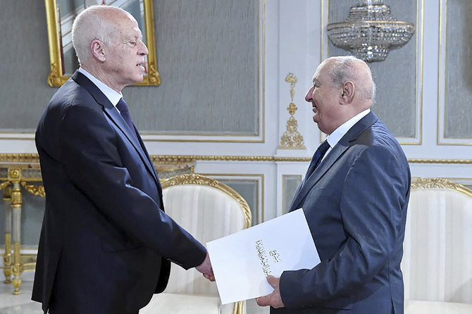 Sadok Belaid submitting a draft of the new constitution to President Kais Saied (L) in Tunis. (AFP file photo)