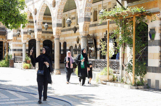 A visitor uses a mobile phone as she walks at Al Azem Palace in Damascus, Syria July 31, 2022. (REUTERS)