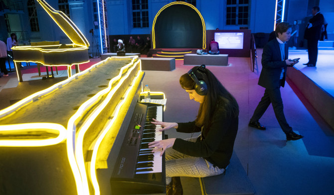 A young woman plays a keyboard wearing headphones during the Moscow Cultural Forum in Moscow, Russia. (AP)