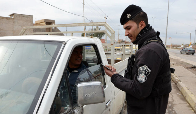 An Iraqi policeman checks the ID of a driver at a checkpoint in Mosul. (AFP)