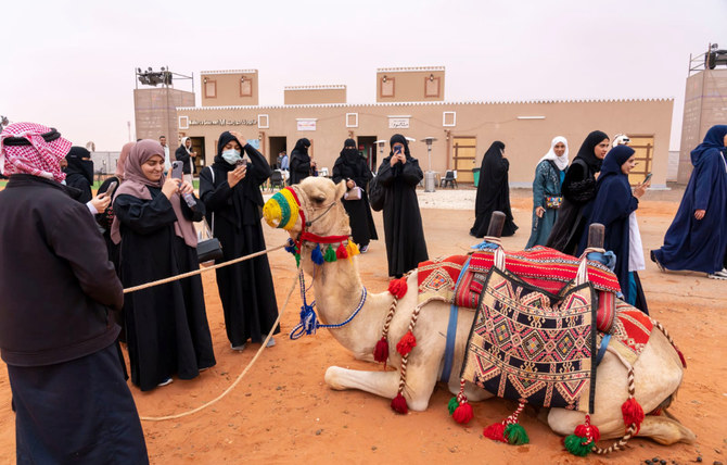 Saudi women take photos of camels at the King Abdulaziz Camel Festival which kicked off in early December. (Supplied/Camel Club)