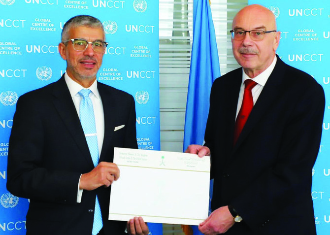 A check is presented to Vladimir Voronkov at the UN headquarters in New York by Saudi Ambassador Abdulaziz Al-Wasel. (Supplied)